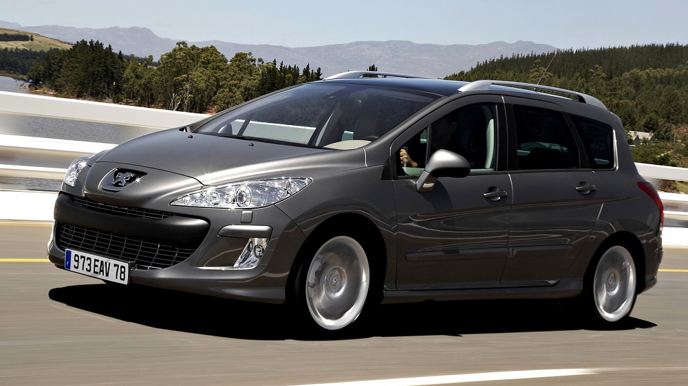 Черный Peugeot 308 едет по дороге