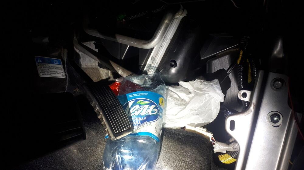 Пластиковая бутылка под педалью газа
